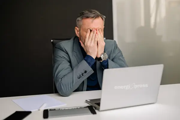 A tired man with his hand on his face